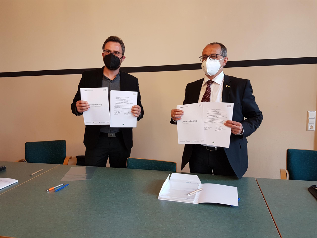 Dr. Jörg Hartmann, stellvertretender Landrat und Dr. Jörg Eulenberger, Leiter des Standorts Süd des BNE-Kompetenzzentrums unterzeichnen die gemeinsame Zielvereinbarung