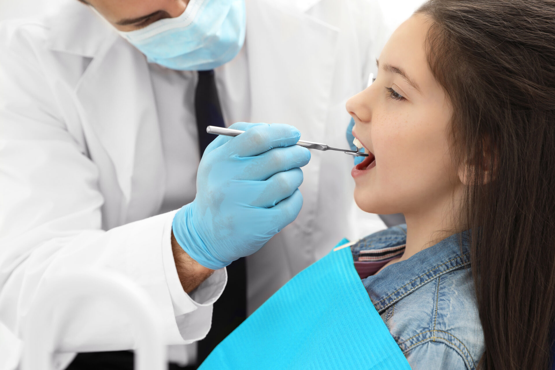 Zahnarzt untersucht die Zähne eines jungen Mädchens