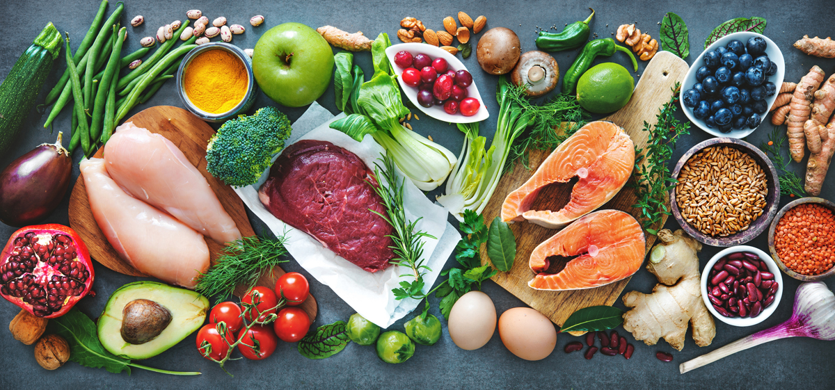 verschiedene Lebensmittel liegen auf einen Tich oder Arbeitsplatte - Apfel, Eier, Limette, Heidelbeeren, Pilze, Nüsee, Ingwer, Fisch